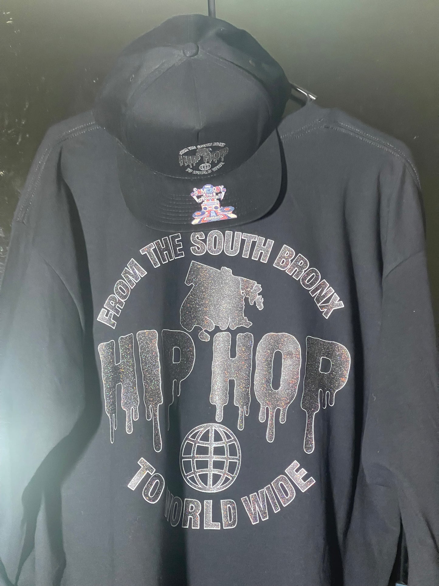 Somebody Say HOOO!™ – From the South Bronx to Worldwide Long-Sleeve Black on Black Glitter Cap includes